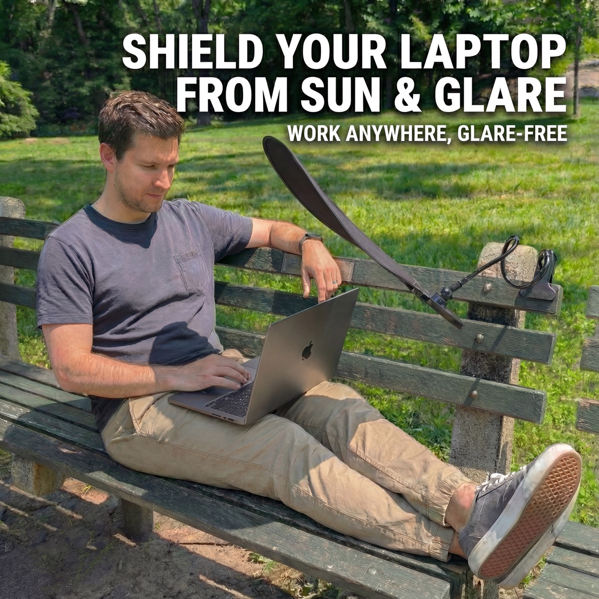 Man using Livvie laptop sun shade on a park bench